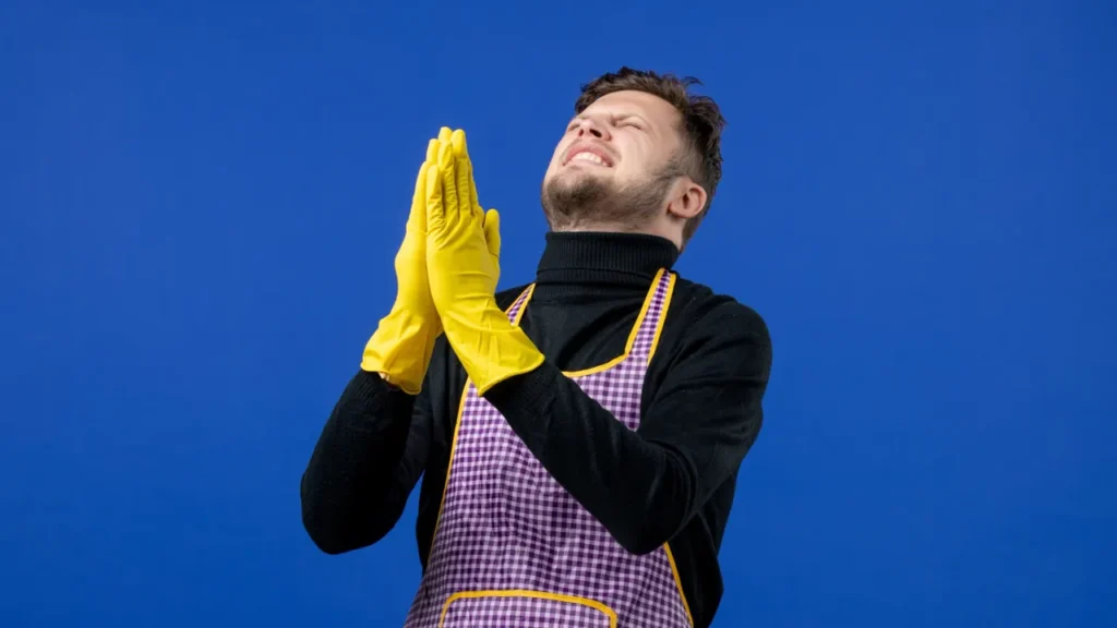 Man praying wearing yellow gloves